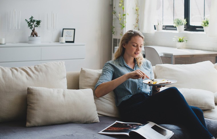 woman eating on couch