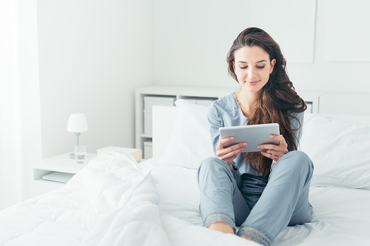 woman on ipad in bed