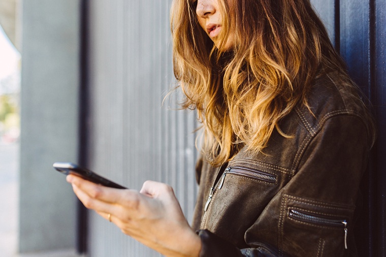 Woman in leather jacket on phone