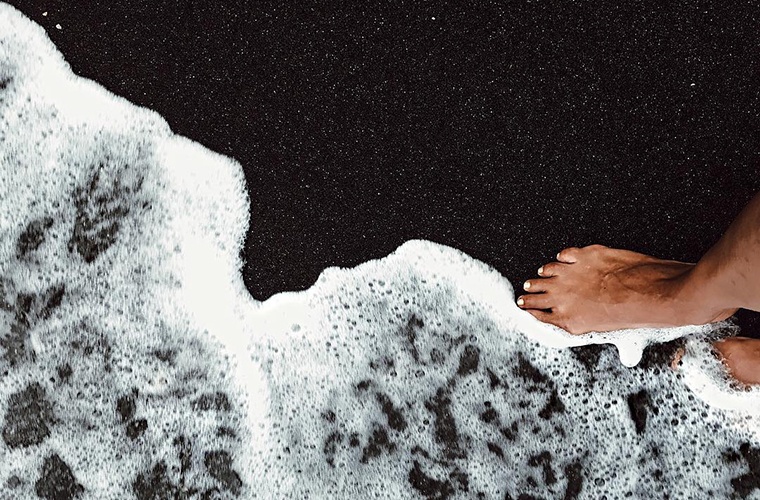 Halle Berry walking on black sand beach from Instagram