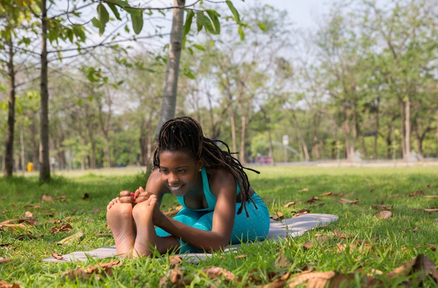 A woman in a park practicing yin yoga poses