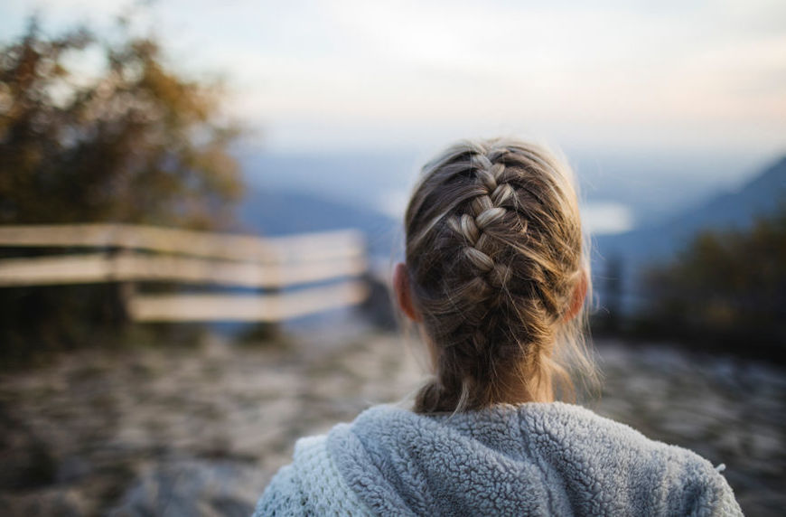 abortion story woman with braid looking at the sunset