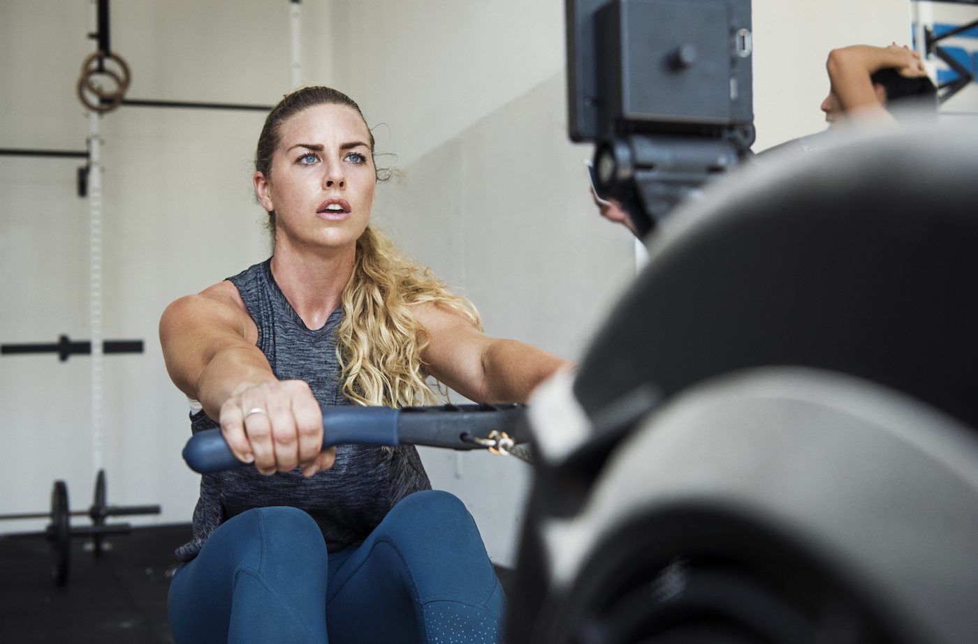 A women exercises on a rowing machine.