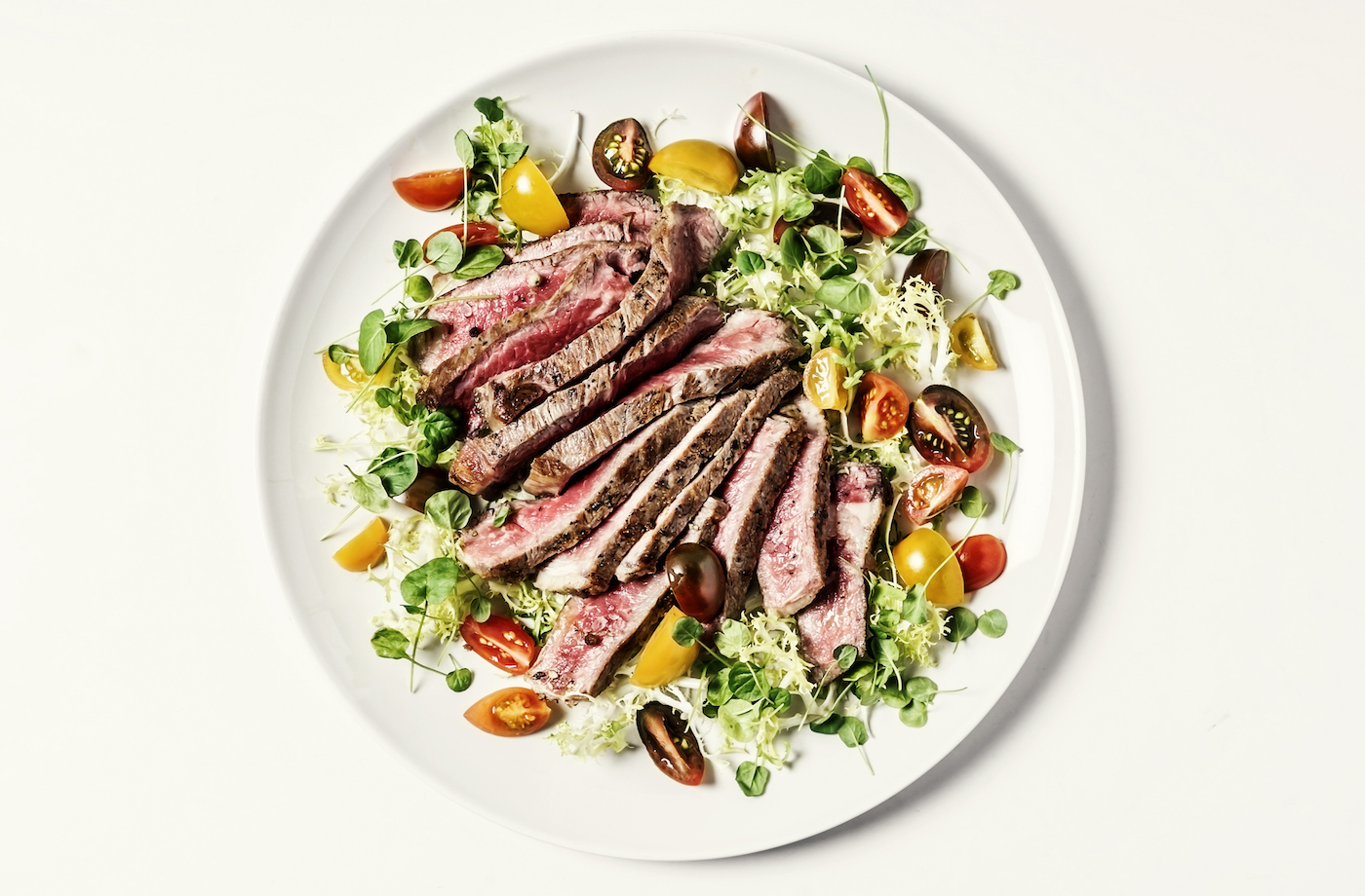 paleo diet macros steak salad with lettuce and tomatoes on a plate