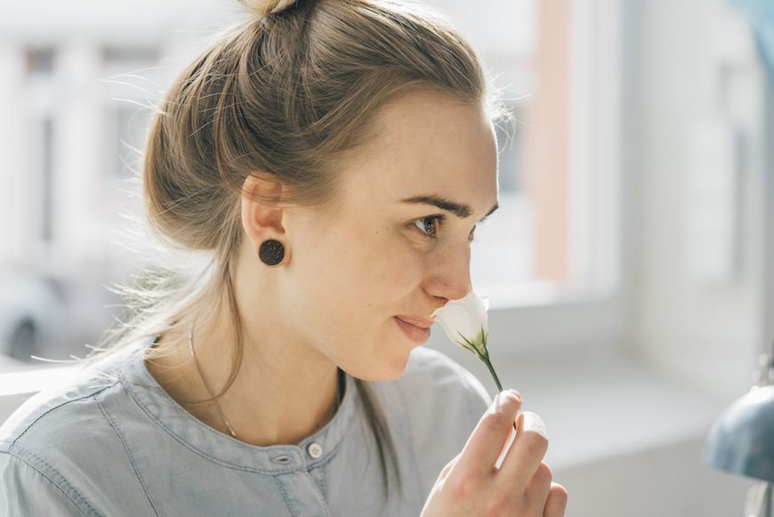 A woman sniffing a flower to illustrate vaginal smells