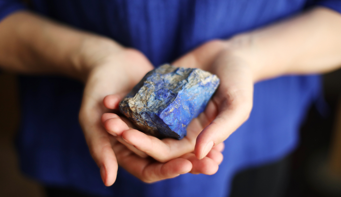 Close-up of a lapis lazuli in the hands of a woman