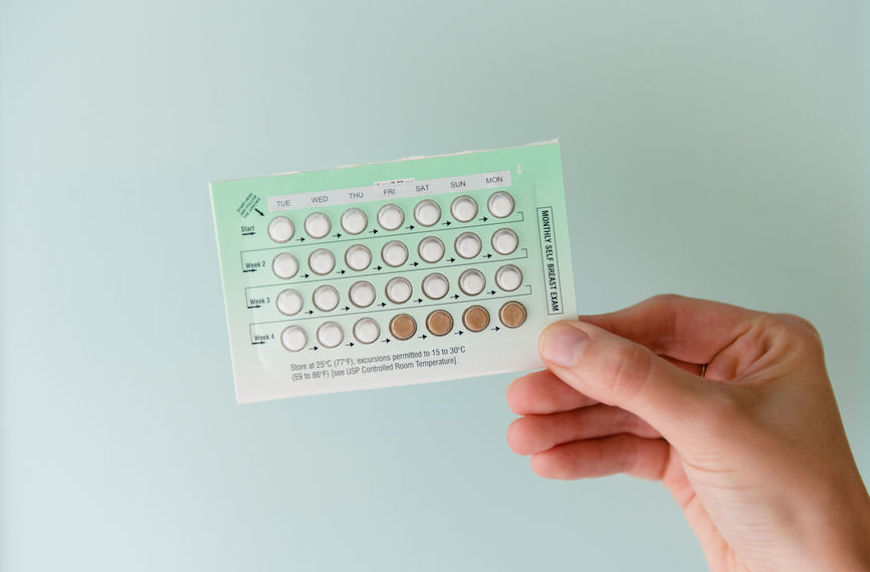 over the counter birth control debate woman holding up pack of birth control pills