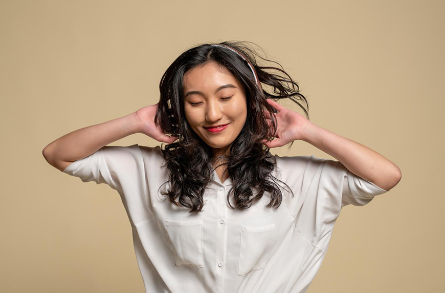woman listening to headphones with dandruff-free hair