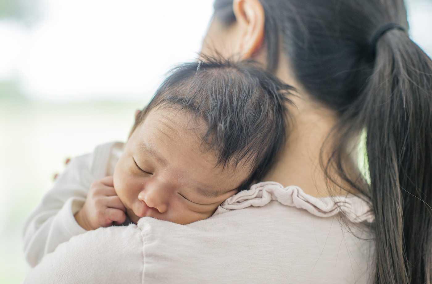 what helps postpartum depression woman holding her newborn baby