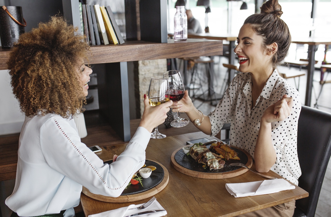 is cooking oil healthy two women toasting with a glass of wine at a restaurant