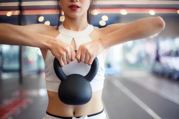 In the Battle Between Kettlebells Vs. Dumbbells, Here's What Will Upgrade Your Sweat Sesh