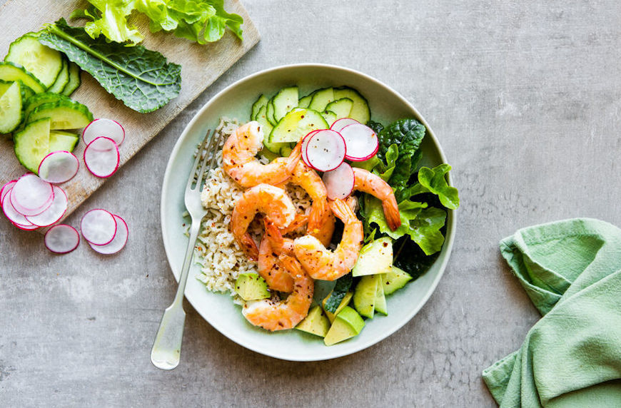 sustainable diet bowl of rice with greens, avocado, and cooked shrimp