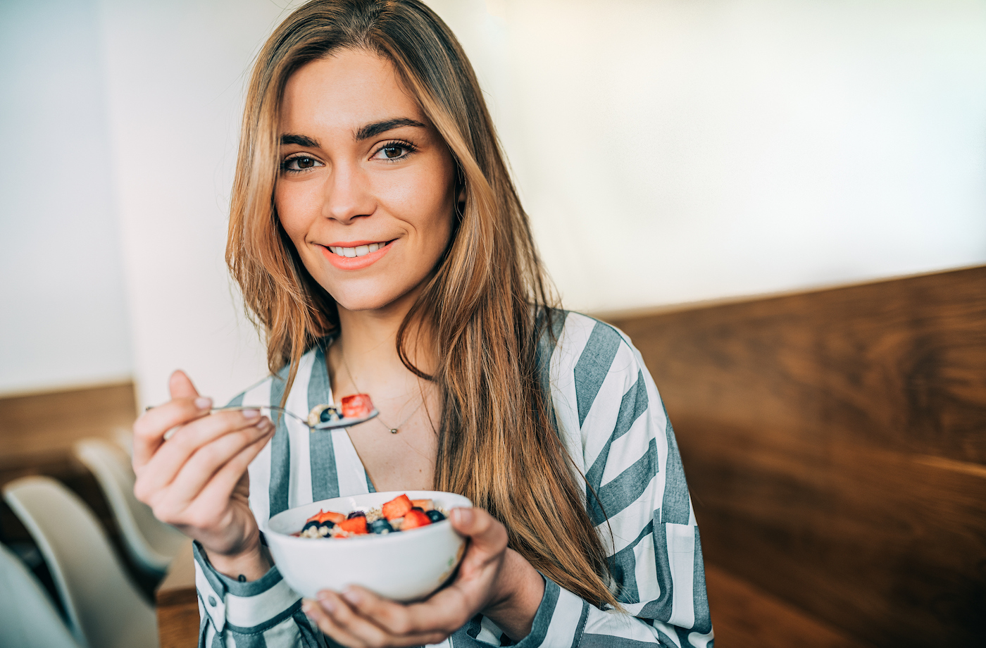 heart healthy snacks woman eating bowl of berries and oats