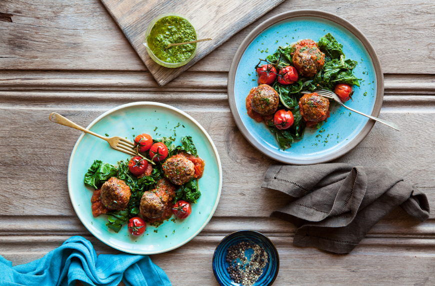 what is meat extender meatballs with sauteed greens and tomatoes on blue plates