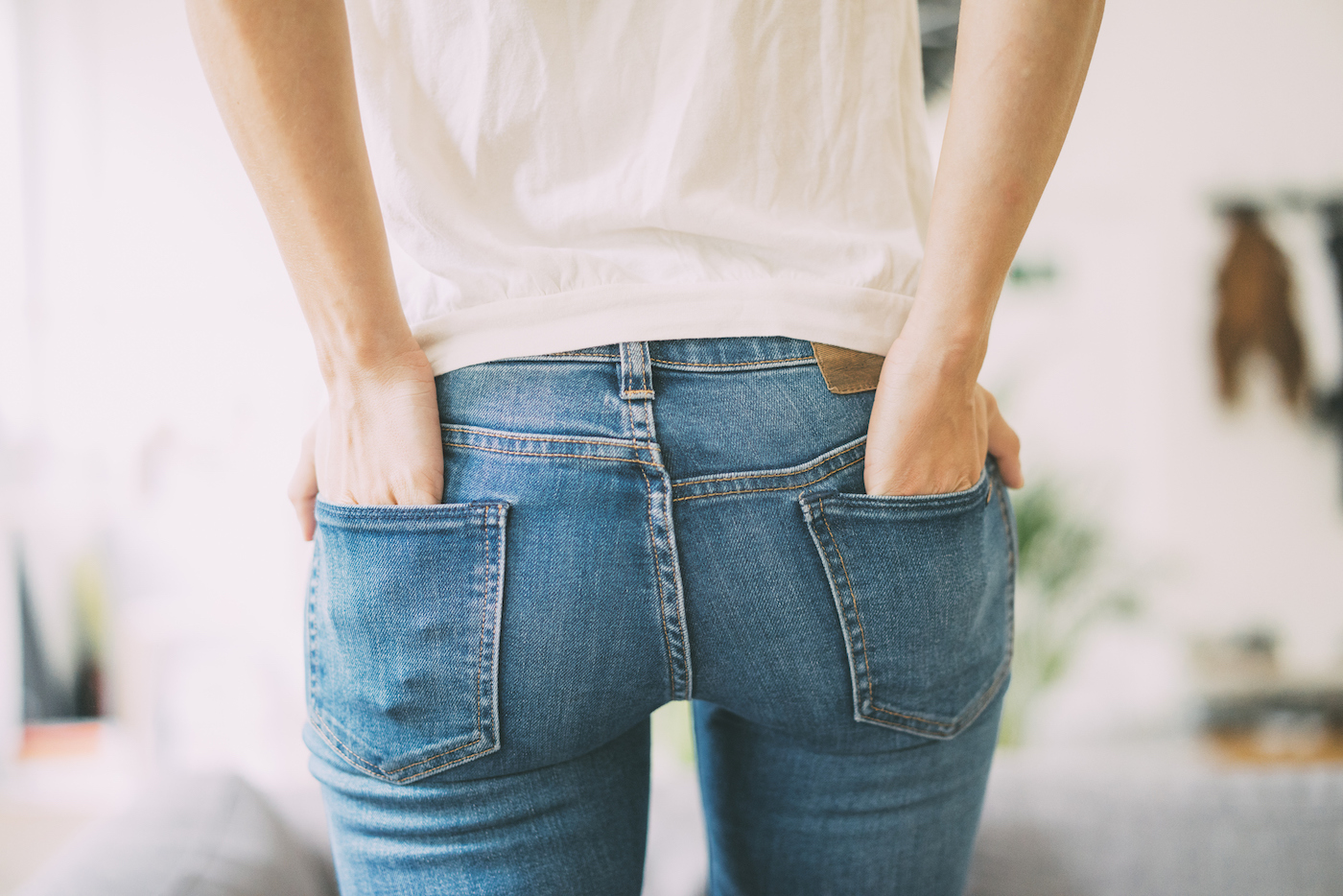 A woman wearing jeans seen from behind.