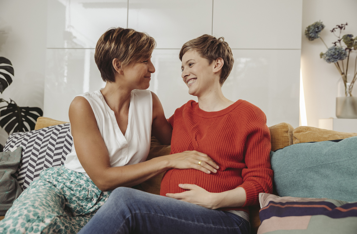 benefits of prenatal and postnatal vitamins pregnant woman on couch with her partner