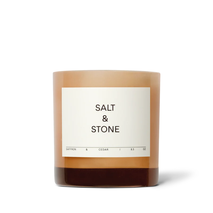salt and stone saffron and cedar candle on a light gray background