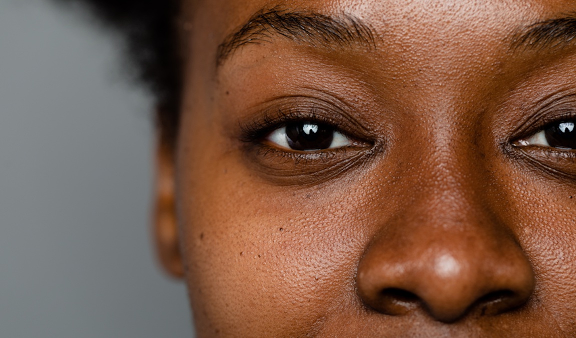 Up close portrait of the eyes and nose of a Black woman.