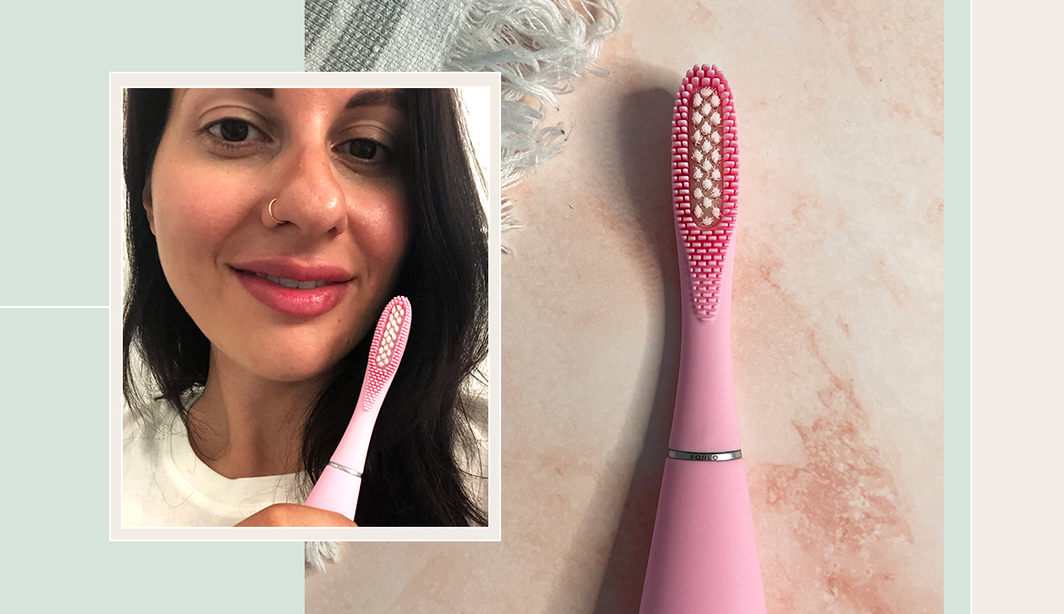 woman holding pink silicone electric toothbrush