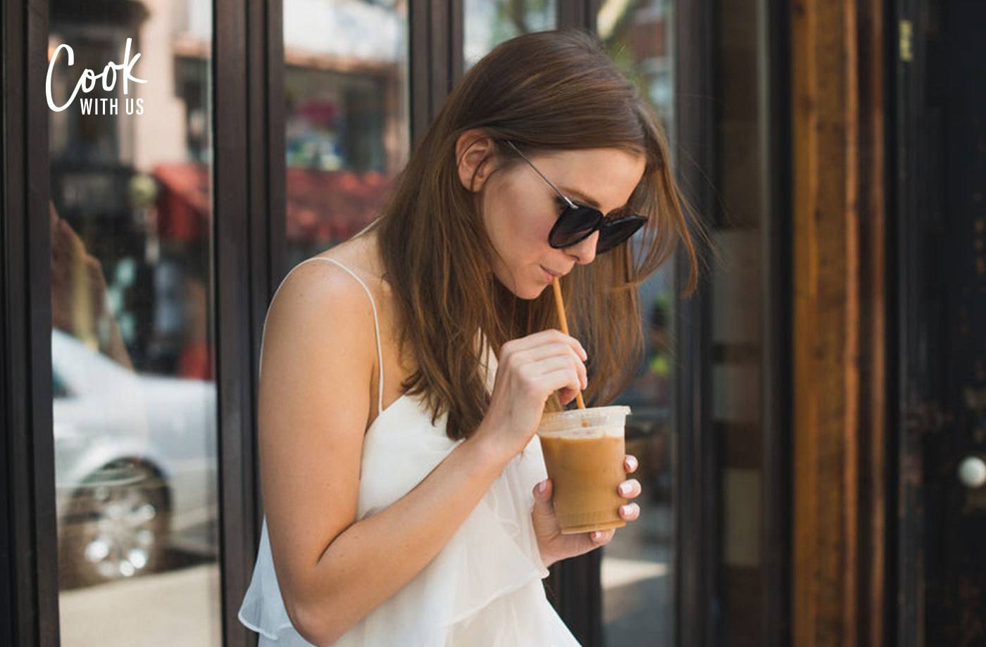 woman drinking iced coffee outdoors