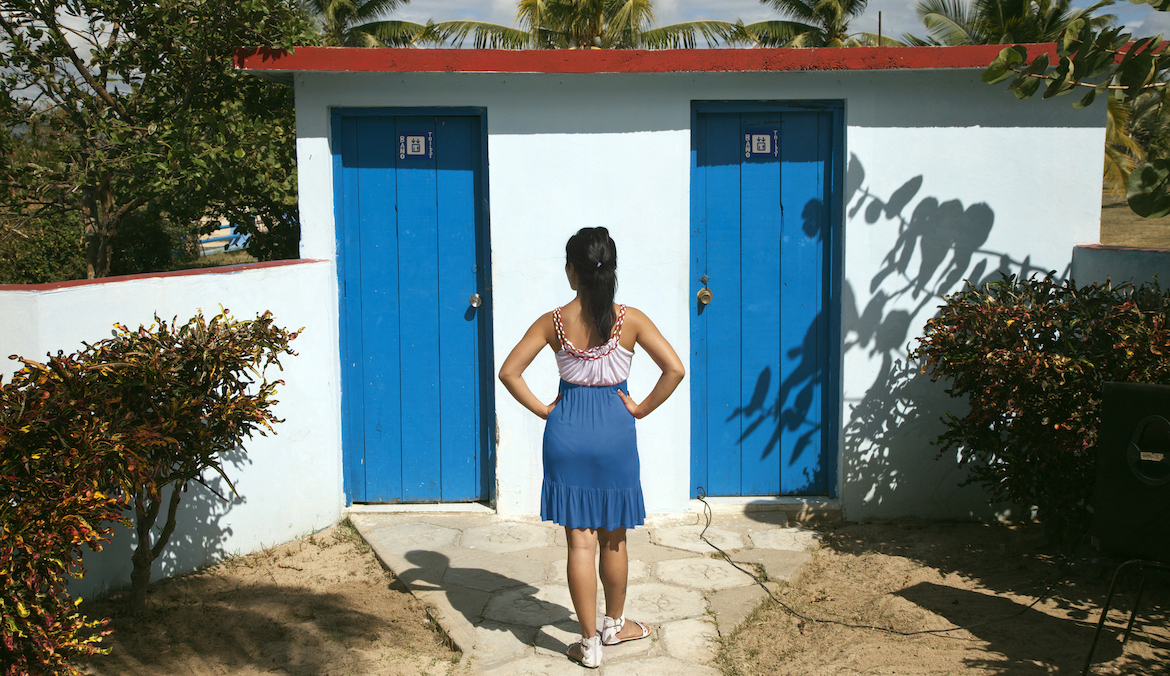 woman standing outside public bathroom doors