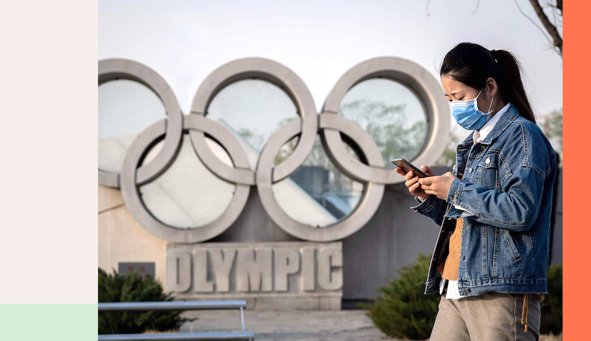 woman walking past olympic rings