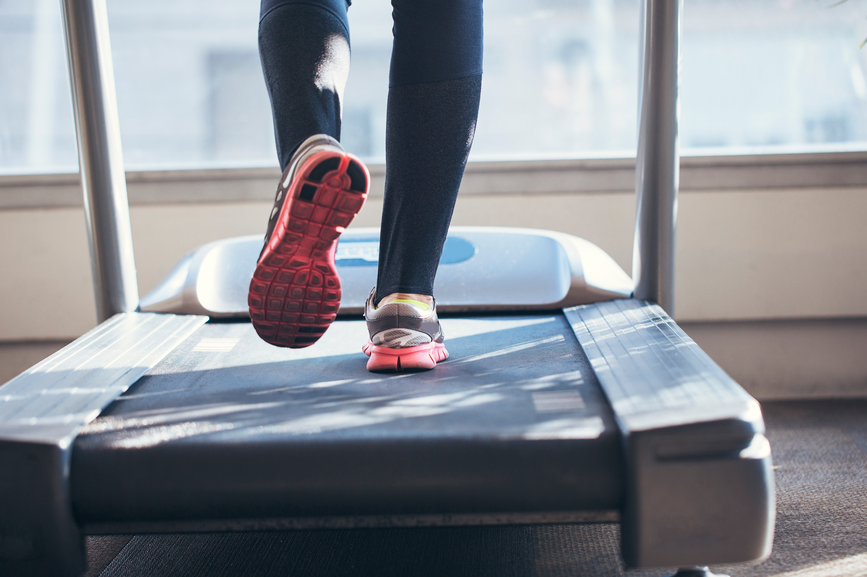 a woman takes steps on a treadmill