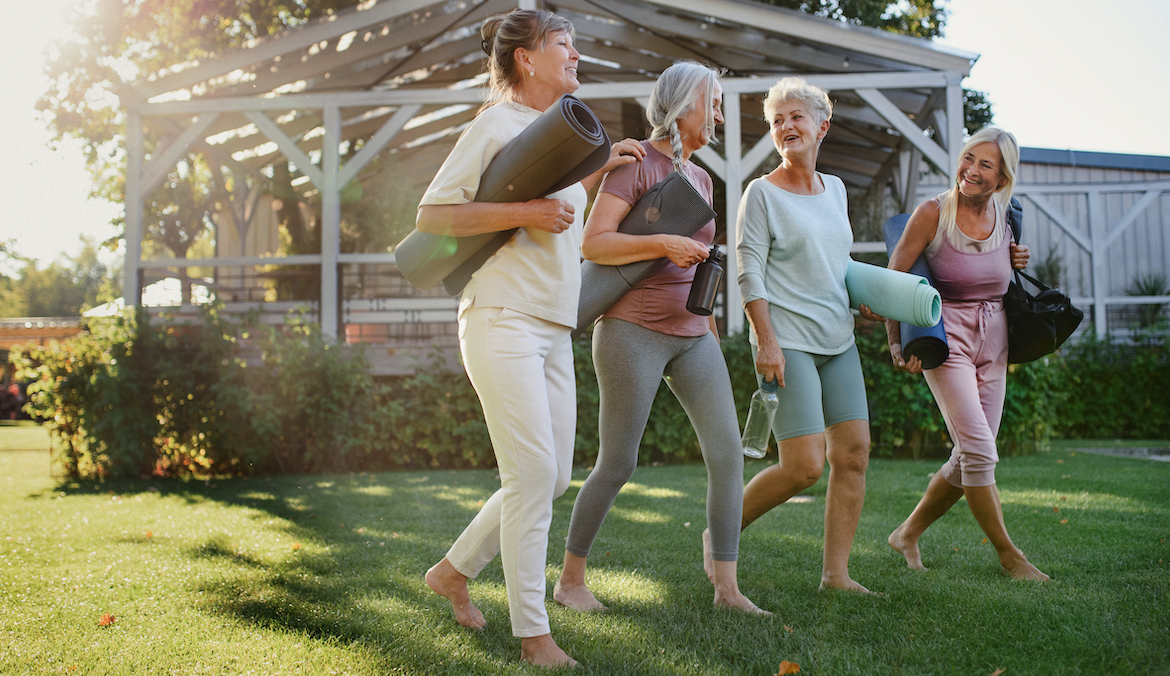 Four older women walking on grass, to illustrate Does walking improve bone density