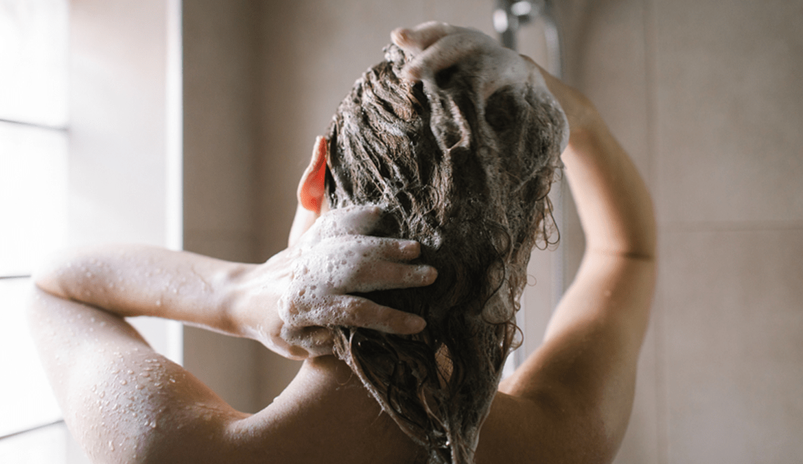 woman using dandruff shampoo in shower