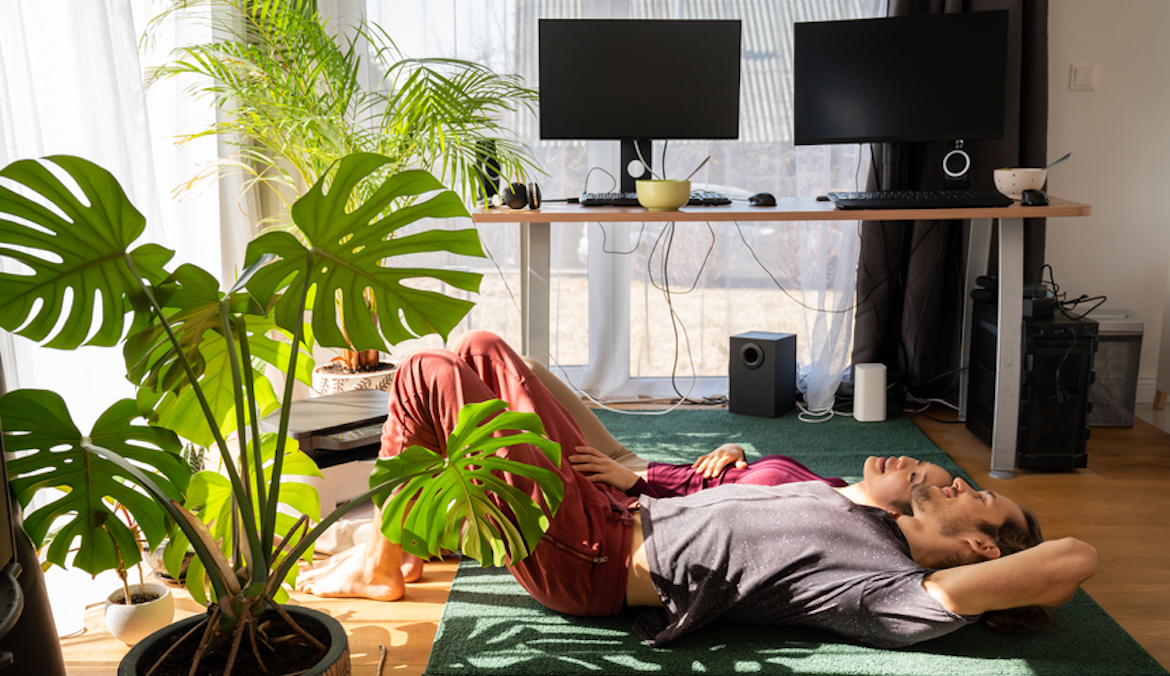 couple lying on the floor at bright stylish home living room full of houseplants