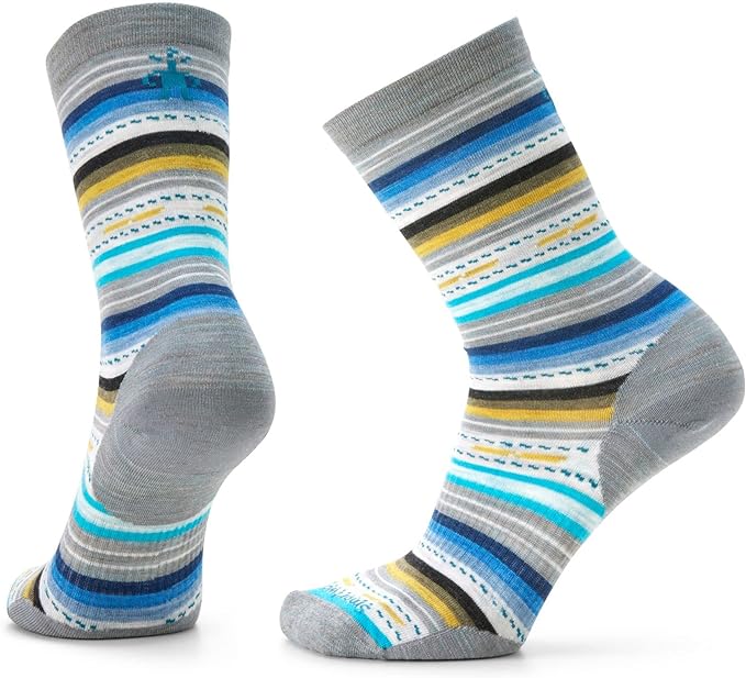 A pair of feet wearing blue and yellow striped smartwool merino wool margarita crew socks