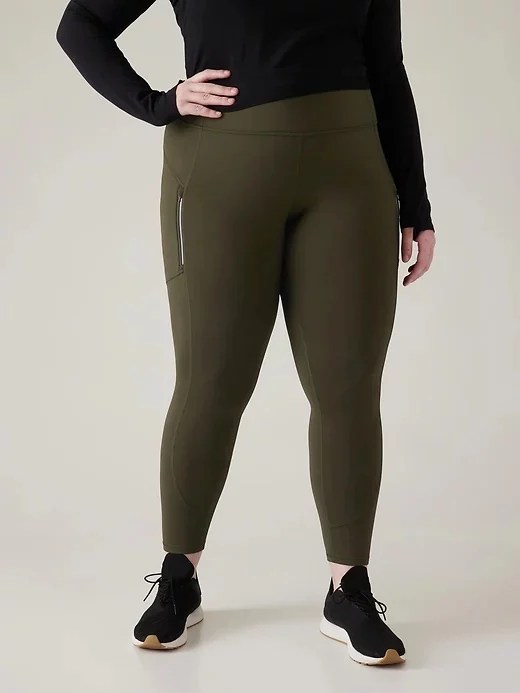 A woman wearing green Athleta Rainier Tights, best leggings for snow