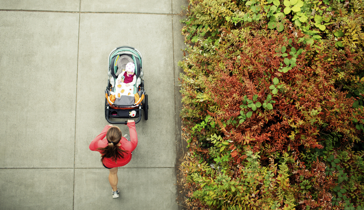 overhead view of a postpartum woman running with a stroller