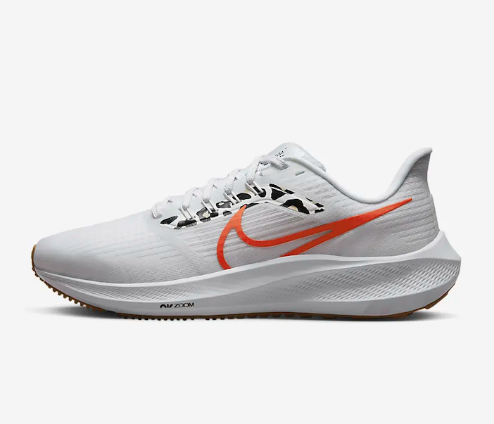 A white Nike sneaker with an orange swoosh sign.