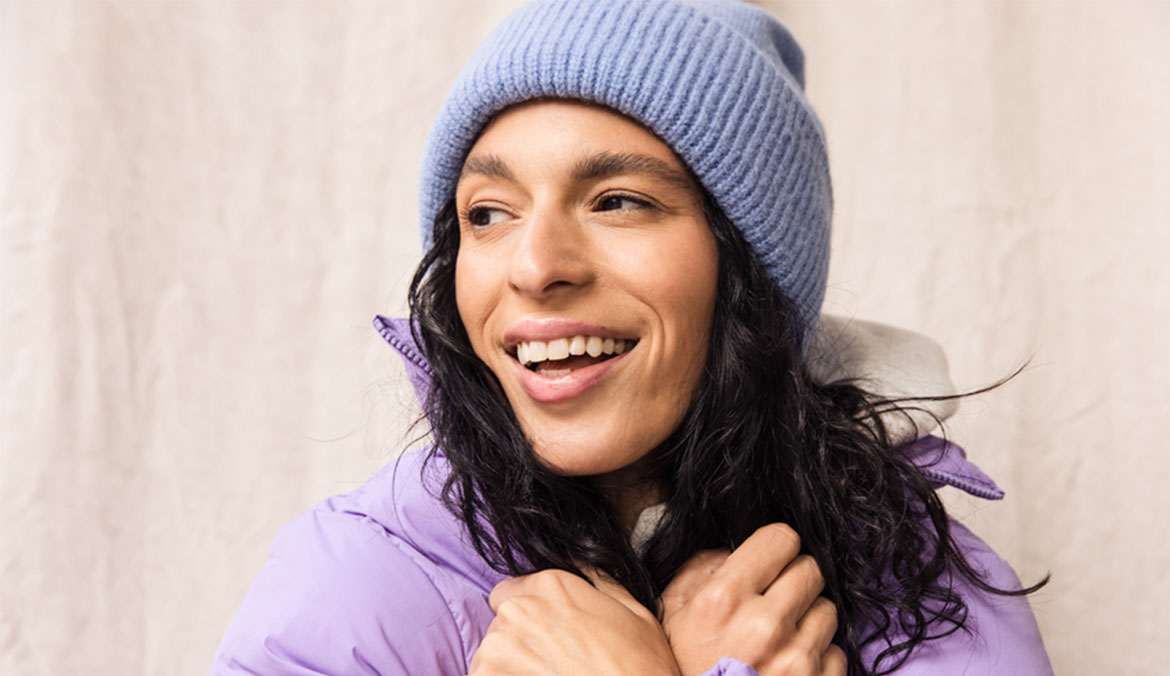 Woman wearing winter beanie and puffer.