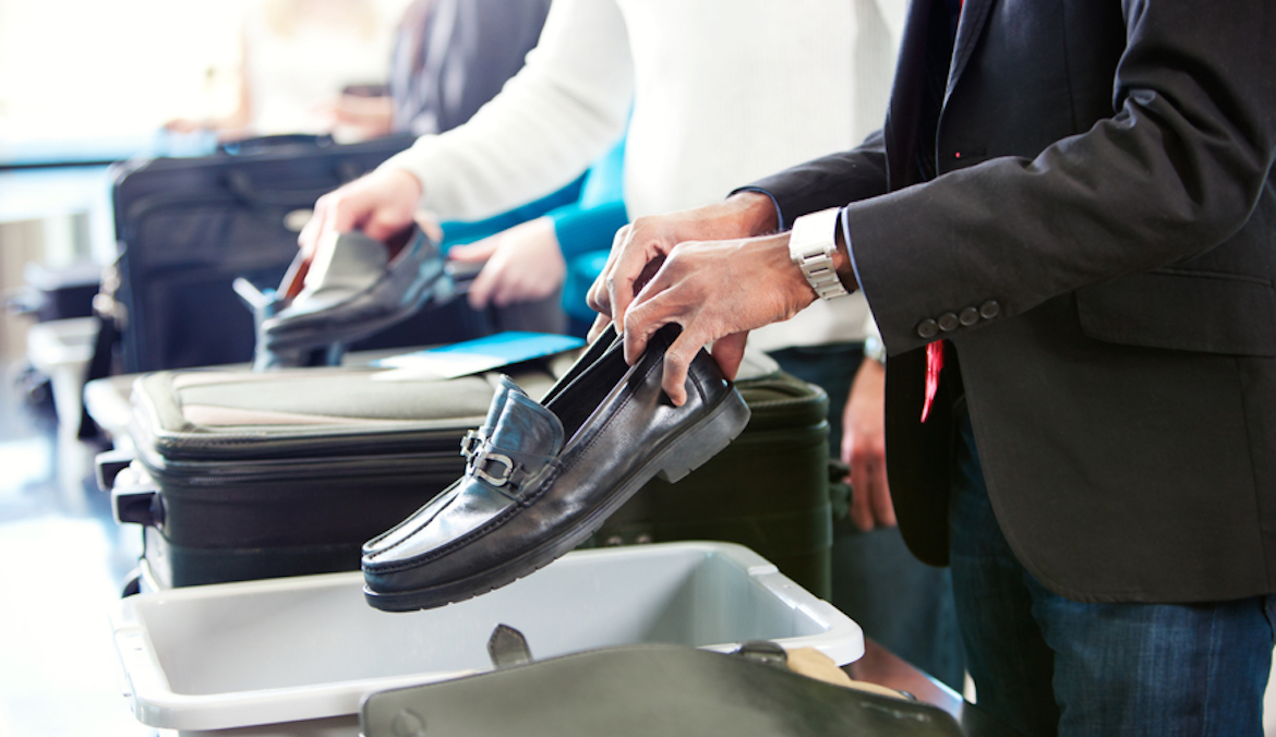 person putting shoes in airport security line