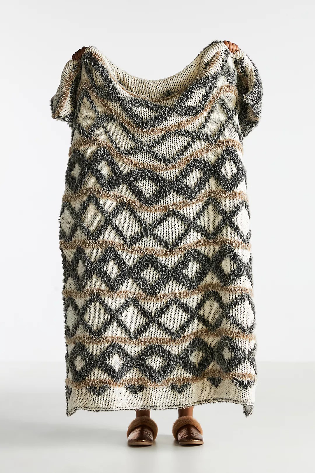 person holding up the georgie cozy knit throw blanket from the anthropologie black friday sale