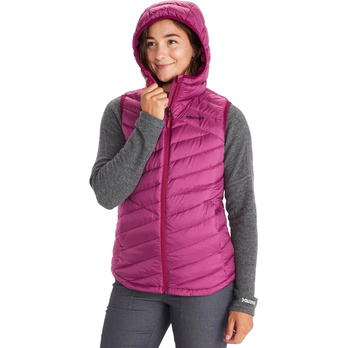 model wearing a bright rose highlander vest which is on sale at backcountry, with a gray long sleeve underneath