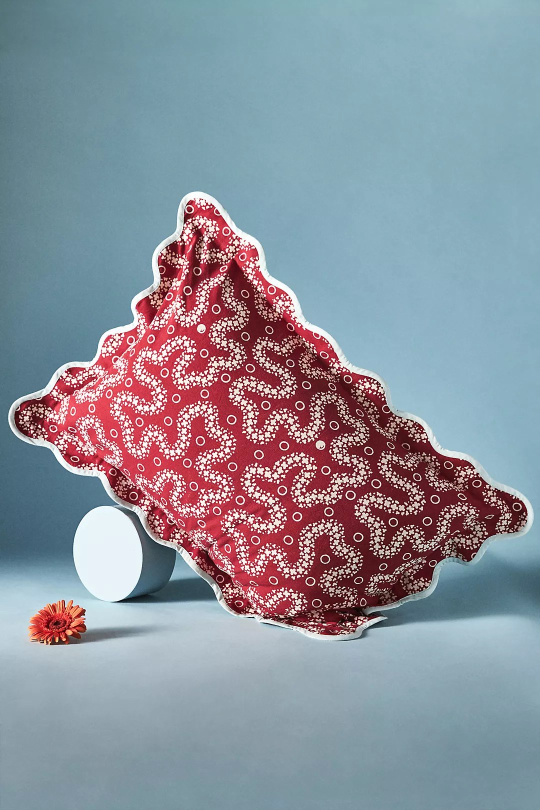 red scalloped pillow on a blue background
