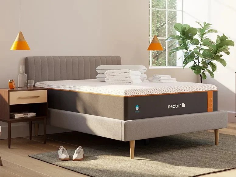 nectar premier copper mattress without bed sheets in a bedroom full of natural light with sneakers on the floor by the bed