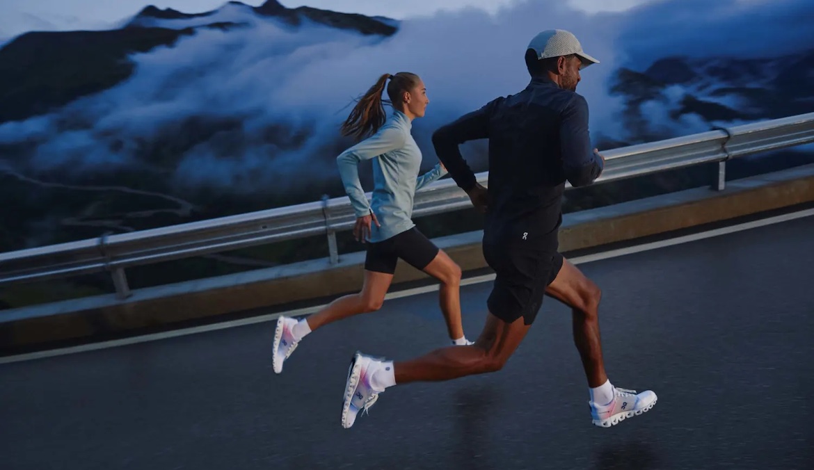 A male and a female runner on a dark road wearring CloudPirme, a running shoe made from carbon emissions