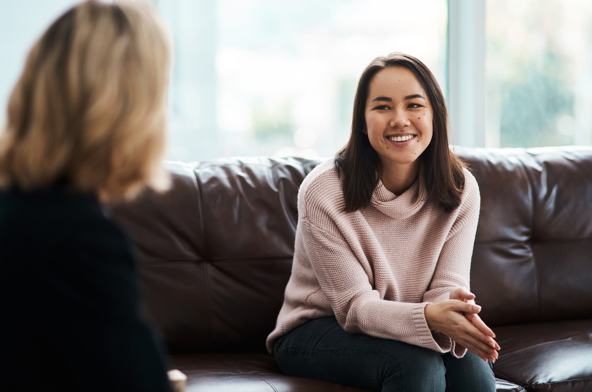 A smiling woman having a therapy session with a psychologist