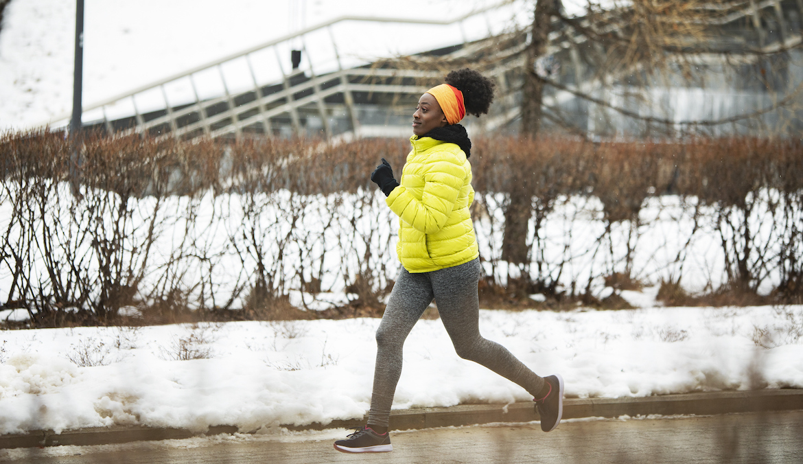Young African woman running outdoors in winter