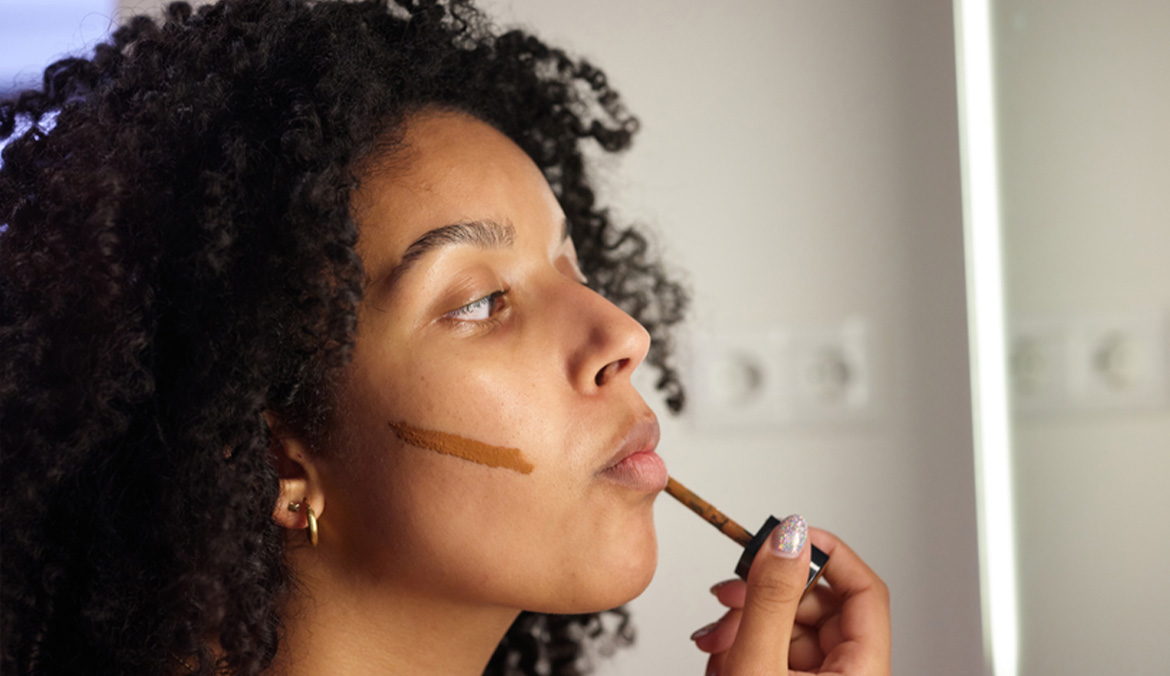 Woman doing contouring with liquid cosmetic