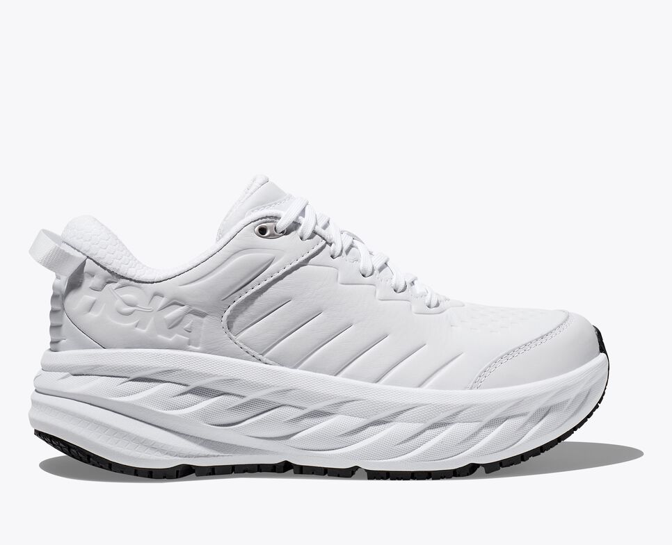 Side view of thick sole white Hoka running shoes.