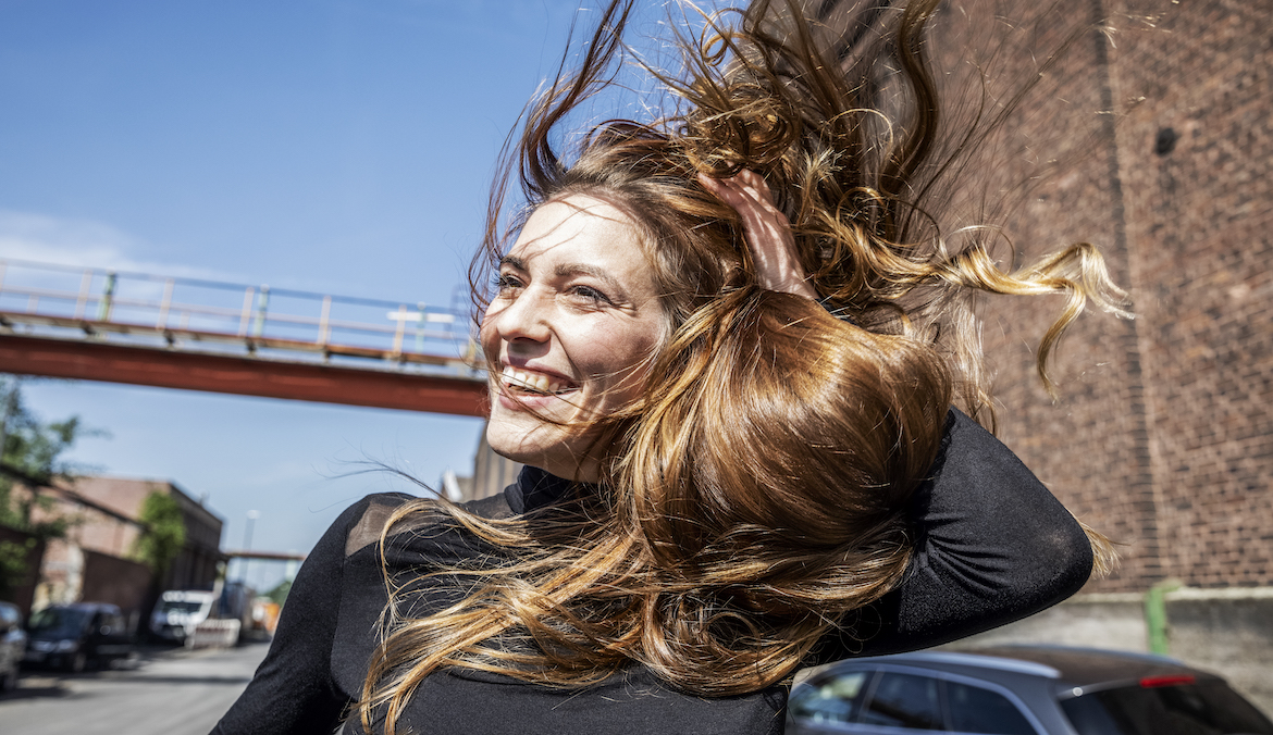 woman with her hair blowing in the wind after using non-aerosol dry shampoo
