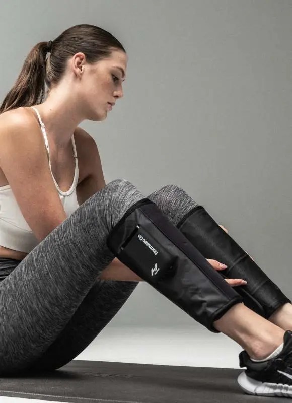 A person wearing normatec go compression sleeves, one of the best work from home gifts