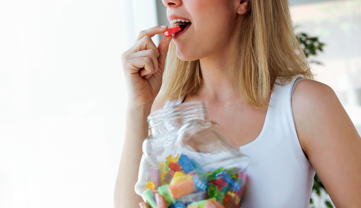 Close-up of woman eating colorful sour candy pre workout