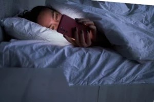 Scrolling on Your Phone in Bed Could Make Your Melatonin Supplements Less Effective, According to Sleep Doctors