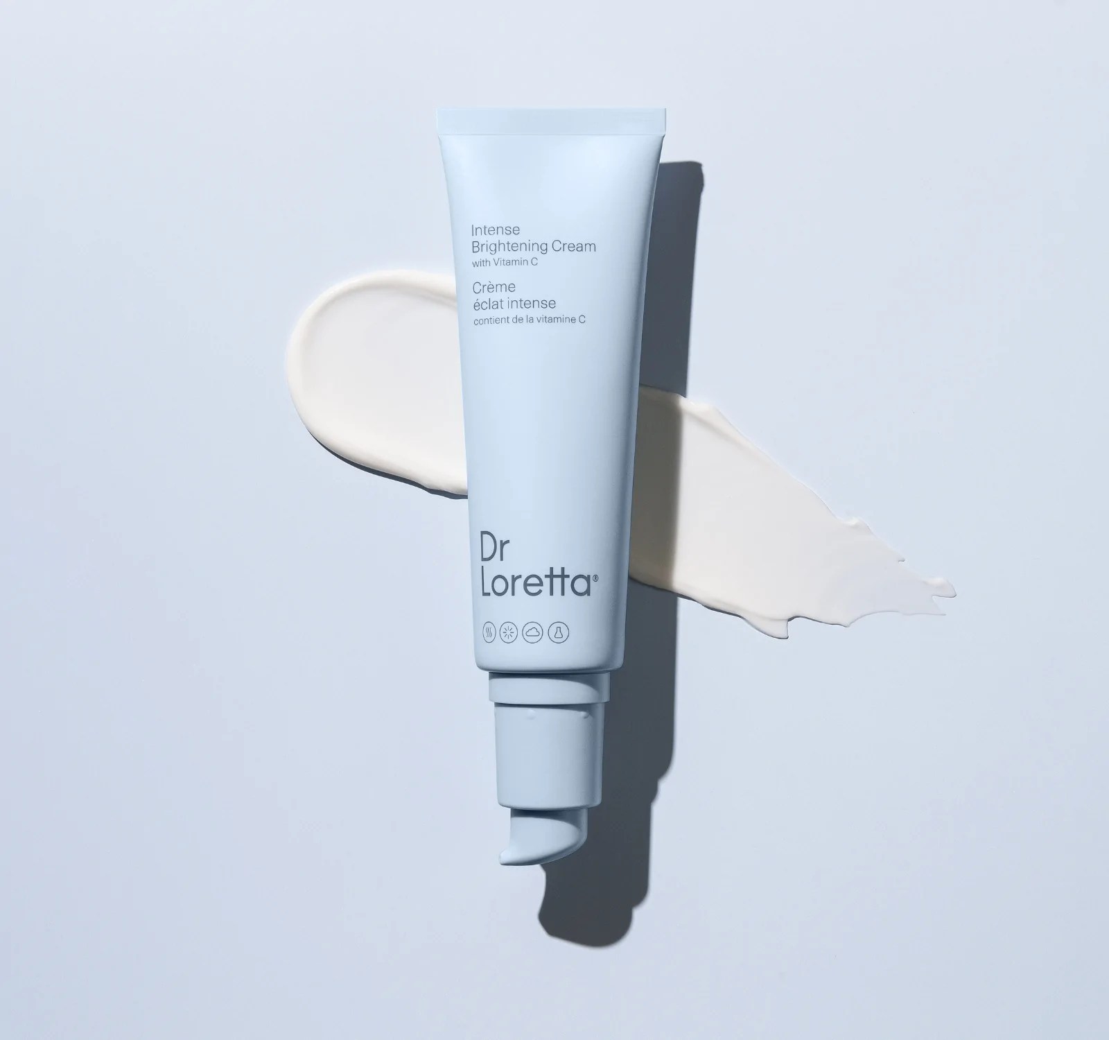 dr. loretta intense brightening cream tube on top of a product swatch on a light blue background